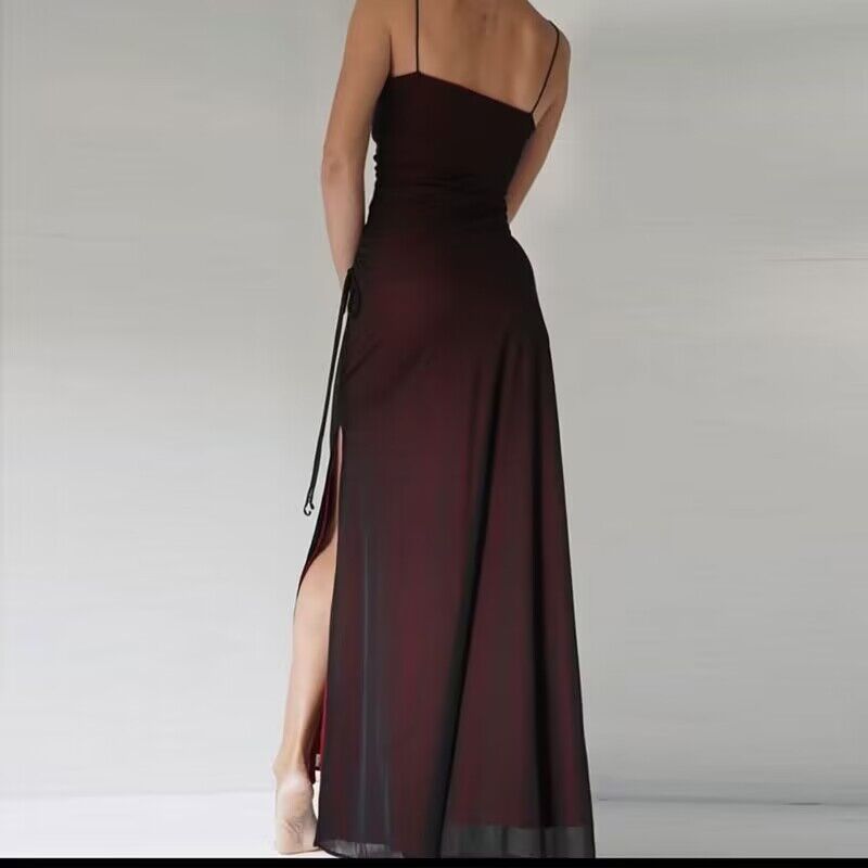 Long burgundy dress with a high slit on a plain background