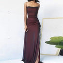 Burgundy evening gown with a slit on a white background