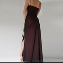 Long burgundy dress with a high slit on a plain background