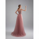Pink evening gown with beaded back in a softly lit room