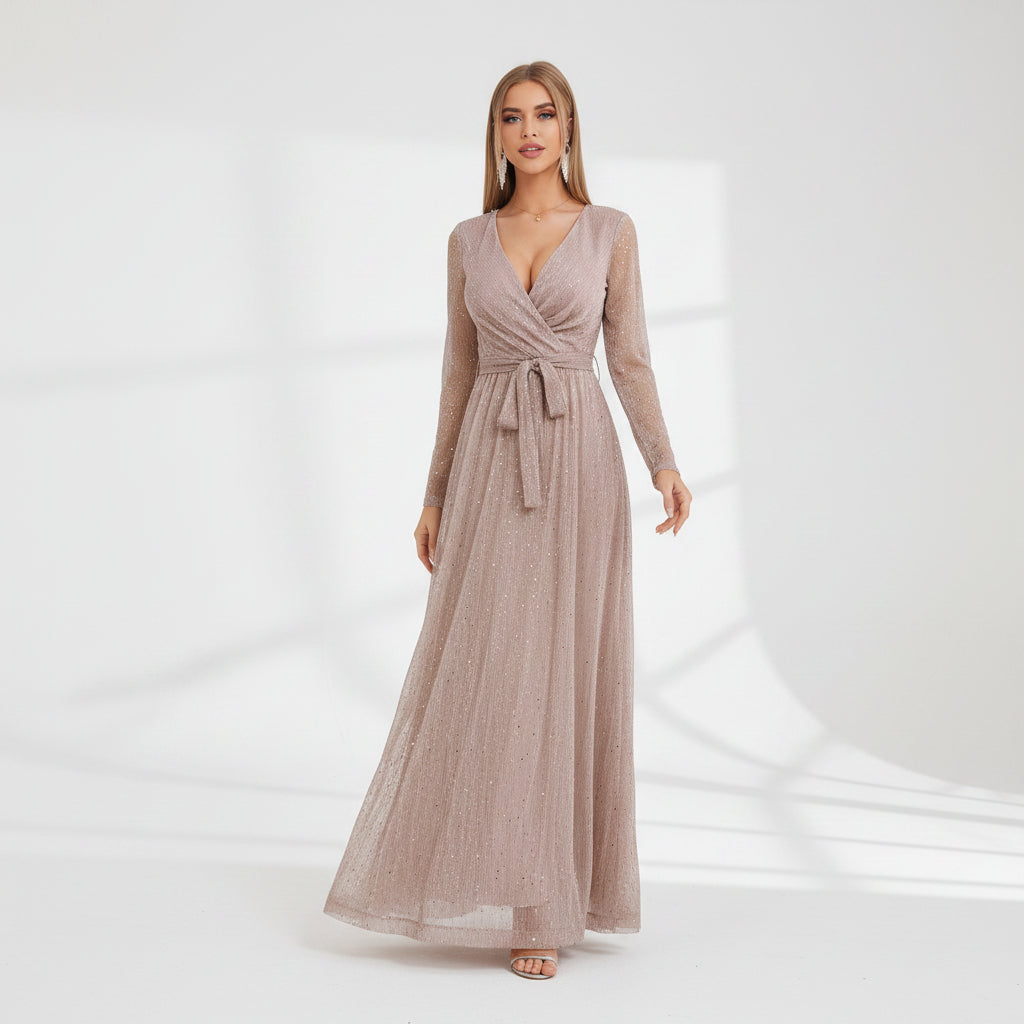 Woman wearing a long, flowing dress in a room with white walls and a small table.